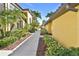 Exterior walkway with lush tropical landscaping including palm trees and manicured shrubbery at 7305 River Hammock Dr # 204, Bradenton, FL 34212