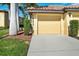 Garage featuring a paved driveway, manicured lawn, and tidy landscaping at 7305 River Hammock Dr # 204, Bradenton, FL 34212