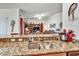 View of the stainless steel kitchen sink with granite countertops looking into a living room with a TV and shelving at 7305 River Hammock Dr # 204, Bradenton, FL 34212