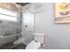 Modern bathroom featuring a tiled shower with glass door and decorative art piece at 7309 Islander Ln, Hudson, FL 34667