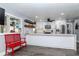 Bright kitchen featuring white cabinets, floating shelves, stainless steel appliances, and stylish accents at 7309 Islander Ln, Hudson, FL 34667