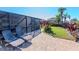 Outdoor patio with lounge chairs, screened in porch and lush landscaping providing relaxation and privacy at 7309 Islander Ln, Hudson, FL 34667