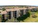Aerial shot of an apartment building with screened patios, lush green lawn and mature trees with view of the community at 8403 Grand Estuary Trl # 204, Bradenton, FL 34212