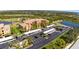 Aerial view of an apartment building with covered parking, lush landscaping, and a nearby lake and golf course at 8403 Grand Estuary Trl # 204, Bradenton, FL 34212