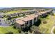 Overhead view of an apartment building with spacious lawns, lush foliage, and a pond, surrounded by mature trees at 8403 Grand Estuary Trl # 204, Bradenton, FL 34212
