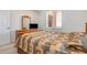 Comfortable carpeted bedroom featuring an open window and a small television on the dresser at 8403 Grand Estuary Trl # 204, Bradenton, FL 34212