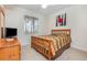 Carpeted bedroom with natural light and a television set with a dresser at 8403 Grand Estuary Trl # 204, Bradenton, FL 34212