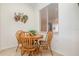 Cozy breakfast nook features natural wood table set and ample natural light from a window at 8403 Grand Estuary Trl # 204, Bradenton, FL 34212