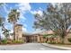 Beautifully landscaped exterior with tropical trees, colorful plants, and a charming entry tower at 8403 Grand Estuary Trl # 204, Bradenton, FL 34212