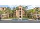 Beautiful condo building featuring multiple balconies and lush landscaping with covered parking spaces at 8403 Grand Estuary Trl # 204, Bradenton, FL 34212