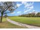 View of the meticulously maintained golf course surrounded by trees, a path and manicured green grass at 8403 Grand Estuary Trl # 204, Bradenton, FL 34212