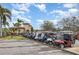 Golf cart parking lot with a row of golf carts with beautiful palm trees and building in the background at 8403 Grand Estuary Trl # 204, Bradenton, FL 34212