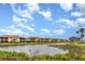Scenic view of the pond behind a row of townhomes, showcasing beautiful landscaping and water views at 8403 Grand Estuary Trl # 204, Bradenton, FL 34212