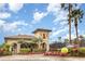 Exterior view of a community tennis center building with lush landscaping and a whimsical giant tennis ball at 8403 Grand Estuary Trl # 204, Bradenton, FL 34212