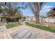 Expansive backyard with patio, seating, pergola, and mature trees offering ample shade and outdoor living space at 908 Woodley Rd, Clearwater, FL 33764