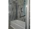 Beautifully renovated bath with tub and shower, stone tile accent wall, and black grab bars at 908 Woodley Rd, Clearwater, FL 33764