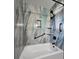 Updated bathroom features a tub, shower with unique tile surround, and modern black hardware at 908 Woodley Rd, Clearwater, FL 33764
