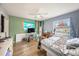 Comfortable bedroom featuring a ceiling fan, wood-look floors, and large window providing natural light at 908 Woodley Rd, Clearwater, FL 33764