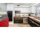 Bright kitchen with stainless steel appliances, black and white cabinets, and wood flooring at 908 Woodley Rd, Clearwater, FL 33764