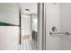 Shower with white tiling and safety bar, plus black and white tiled floors at 105 4Th Ne Ave # 405, St Petersburg, FL 33701