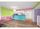 Bright living room with wood floors, vibrant accent walls, and an open layout to the kitchen with stainless appliances at 105 4Th Ne Ave # 405, St Petersburg, FL 33701