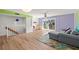 Bright living room with wood floors, gray sectional, colorful rug, and sliding glass doors to a balcony at 105 4Th Ne Ave # 405, St Petersburg, FL 33701