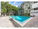 Sparkling outdoor community pool with poolside furniture, landscaping and building balconies at 105 4Th Ne Ave # 405, St Petersburg, FL 33701