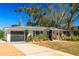 Charming single-story home with a well-maintained lawn, inviting entrance, attached garage and lush landscaping at 1131 60Th Ave S, St Petersburg, FL 33705