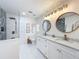 Bright bathroom featuring double vanity, granite counters, and a tiled shower with rainfall shower head at 11335 Mcmullen Loop, Riverview, FL 33569