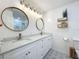 Bathroom featuring double vanity, granite counters, round mirrors, and decorative tile flooring at 11335 Mcmullen Loop, Riverview, FL 33569