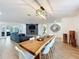 Open-concept area featuring hardwood floors, a modern light fixture, and a large wooden dining table at 11335 Mcmullen Loop, Riverview, FL 33569