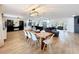 Open-concept area featuring hardwood floors, a modern light fixture, and a large wooden dining table at 11335 Mcmullen Loop, Riverview, FL 33569