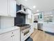 Bright kitchen featuring white cabinets, stainless steel appliances, and a stylish blue backsplash at 11335 Mcmullen Loop, Riverview, FL 33569