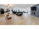 Open-concept living room with modern decor, fireplace, and a spacious dining area with hardwood flooring at 11335 Mcmullen Loop, Riverview, FL 33569