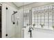 Bright bathroom showcasing a glass-enclosed shower, stylish tile, and unique glass block window for natural light at 12037 Mountbatten Dr, Tampa, FL 33626