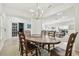 Open-concept dining area with a wooden table, six chairs, a chandelier, and views into the living room and kitchen at 12037 Mountbatten Dr, Tampa, FL 33626