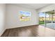 Bright bedroom featuring hardwood flooring, large window, and sliding glass door to the backyard at 12652 Glenn Creek Dr, Riverview, FL 33569