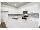 Bright kitchen features white cabinets, a quartz countertop, stainless steel appliances and tile backsplash at 12652 Glenn Creek Dr, Riverview, FL 33569