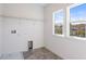 Well-lit laundry room with gray tile flooring and utility sink hookup at 12652 Glenn Creek Dr, Riverview, FL 33569