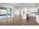 Open concept living area featuring hardwood flooring, large windows, and a modern kitchen at 12652 Glenn Creek Dr, Riverview, FL 33569