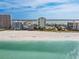 A stunning aerial view of beachfront condos along a pristine sandy beach and clear blue ocean at 1390 Gulf Blvd # 102, Clearwater, FL 33767