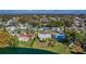 An aerial view of a lakeside residential area, with trees, lawns and blue water at 1484 Gladys Cir, Dunedin, FL 34698