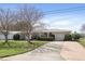 Charming single-story home featuring a well-manicured lawn, mature landscaping, and an attached two-car garage at 1484 Gladys Cir, Dunedin, FL 34698