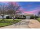 Charming single-story home featuring a well-manicured lawn, mature landscaping, and an attached two-car garage at 1484 Gladys Cir, Dunedin, FL 34698