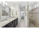 Bathroom featuring double sinks, granite countertops, and a walk-in shower at 16333 Treasure Point Dr, Wimauma, FL 33598