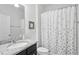 Clean bathroom with granite countertop, modern sink, and shower-tub combination with floral curtain at 16333 Treasure Point Dr, Wimauma, FL 33598