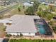 Aerial view of a home featuring a screened pool, spacious roof, and well-maintained landscaping at 182 Rotonda N Blvd, Rotonda West, FL 33947