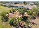 Landscaped backyard features a variety of native plants and brick walking paths with neighboring houses in the background at 182 Rotonda N Blvd, Rotonda West, FL 33947