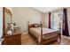 Bedroom features a bed, a dresser, a mirror, a window, and hardwood floors at 182 Rotonda N Blvd, Rotonda West, FL 33947