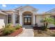 Elegant home exterior showcasing a grand entrance with double doors and meticulous landscaping at 182 Rotonda N Blvd, Rotonda West, FL 33947